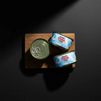 Тунець у власному соку POLAR Seafood у консервних банках, композиція на дерев’яній дошці, вигляд зверху