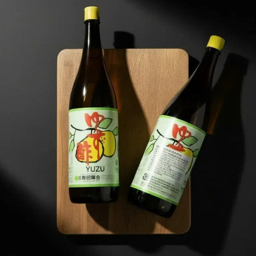 Сік юзу KISHIDA SHOKAI у скляній пляшці, на дерев’яній дощечці, фронтальний ракурс, склана пляшка ілюстрація