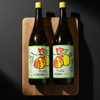 Сік юзу KISHIDA SHOKAI у скляній пляшці, на дерев’яній дощечці, фронтальний ракурс, скляна пляшка пряма.